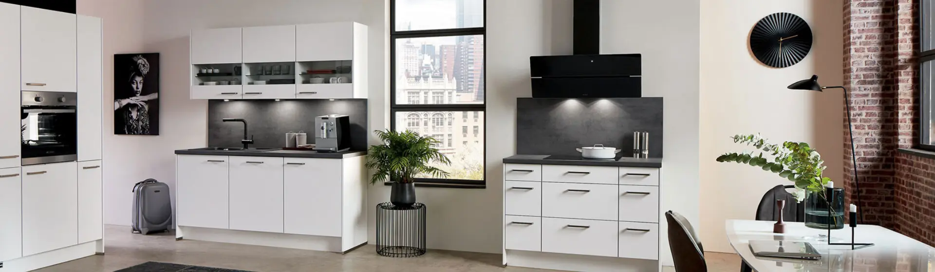 Moderne Küche mit weißen Schränken, eleganten Geräten und dunklen Arbeitsplatten Moderne Küche mit weißen Schränken, eleganten Geräten und dunklen Arbeitsplatten